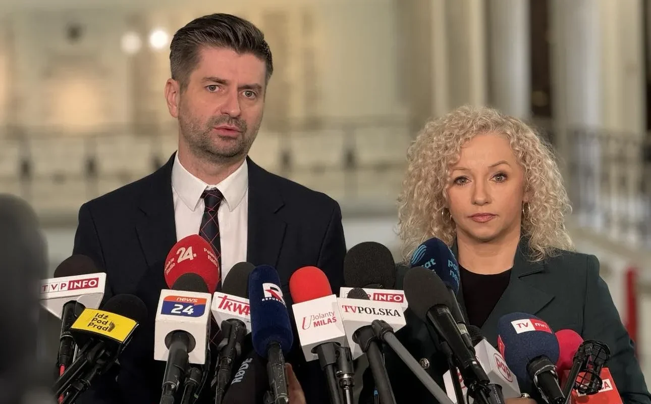 Dwóch przedstawicieli przemawia na konferencji prasowej, stojąc za licznymi mikrofonami, w związku z ochroną polskich rodzin przed przemocą.