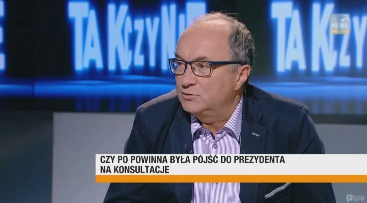 Mężczyzna w okularach i marynarce mówi w studiu telewizyjnym, a na dole ekranu widoczny jest napis: „Czy PO powinna była pójść do prezydenta na konsultacje”.