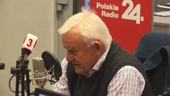Starszy mężczyzna siedzi przy mikrofonie w studiu Polskie Radio 24 podczas rozmowy radiowej.