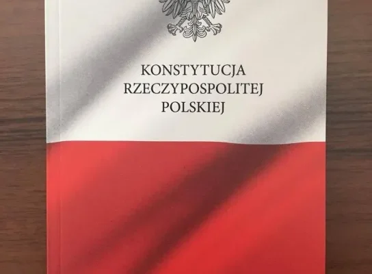 Okładka książki „Konstytucja Rzeczypospolitej Polskiej” z godłem Polski i biało‑czerwonym motywem flagi.
