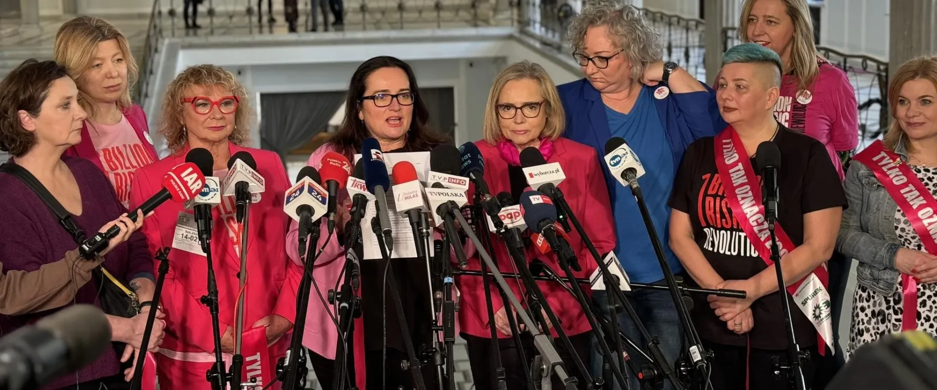 Grupa kobiet‑polityczek Lewicy stoi na konferencji prasowej otoczona licznymi mikrofonami, prezentując projekt zmiany definicji gwałtu i hasło „Tylko TAK” oznaczające zgodę.