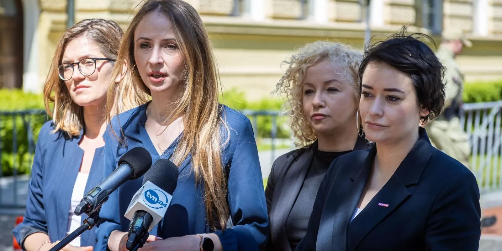 Cztery kobiety stojące przy mikrofonach podczas konferencji prasowej na świeżym powietrzu.