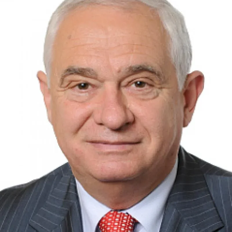 Portret starszego mężczyzny w garniturze i czerwonym krawacie na białym tle, użyty jako ilustracja do wypowiedzi o konflikcie wokół nowelizacji ustawy o IPN.