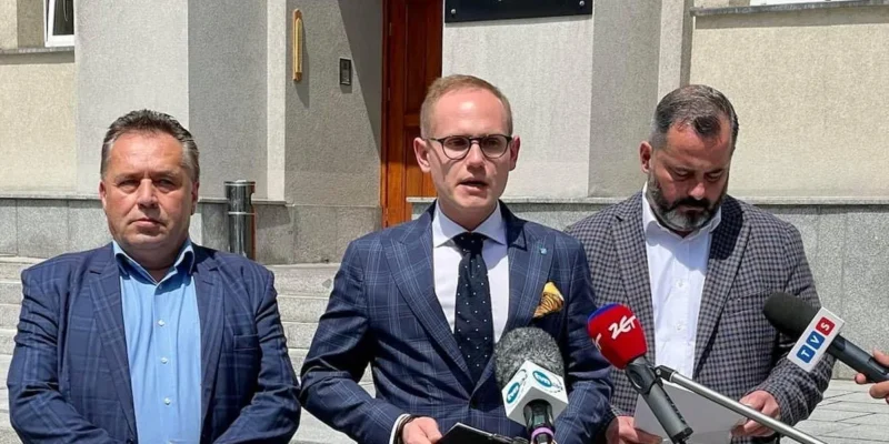 Na zdjęciu trzech mężczyzn stoi przed budynkiem, gdzie odbywa się konferencja prasowa, trzymając mikrofony i dokumenty.