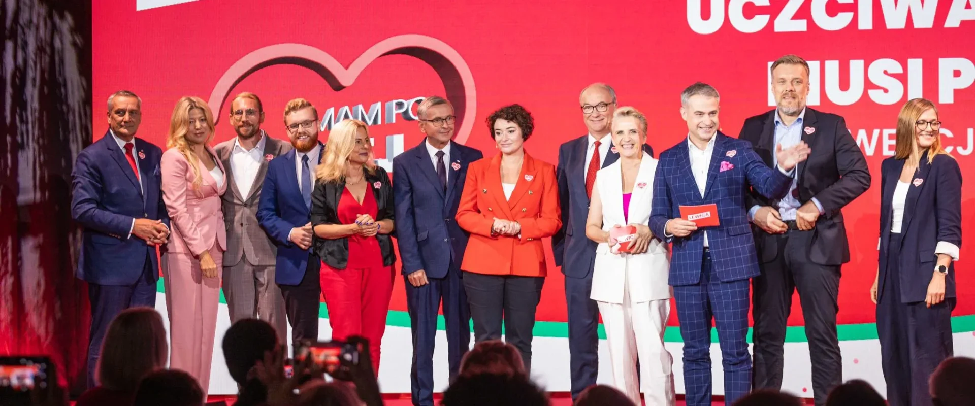 Grupa osób w eleganckich strojach stoi na scenie przy czerwonym tle z hasłem „Uczciwa praca musi popłacać” podczas wydarzenia Lewicy.