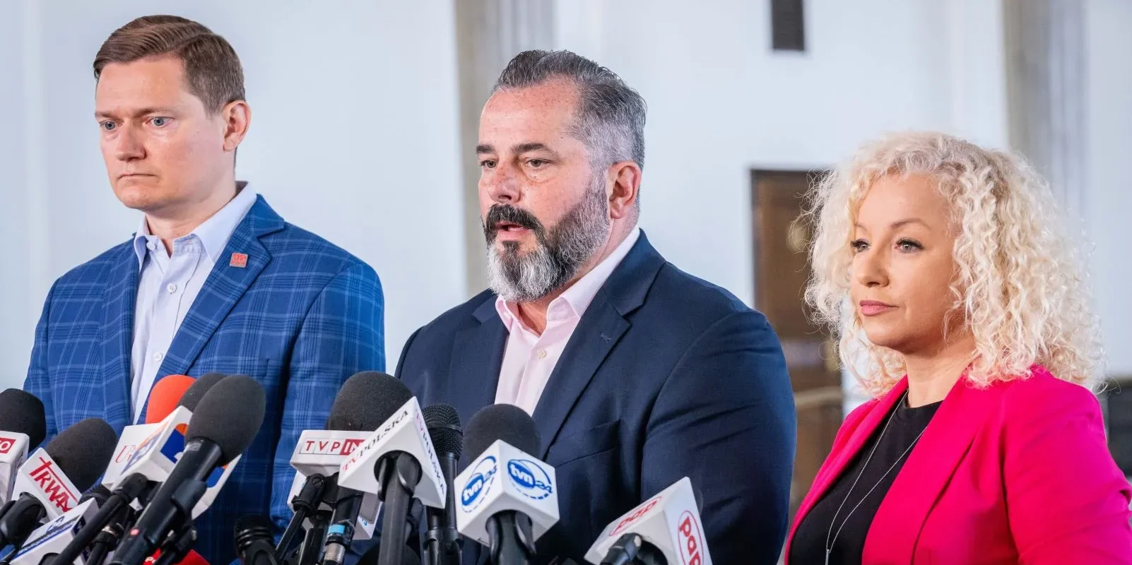 Trzy osoby stojące przy mikrofonach na konferencji prasowej Lewicy w sprawie ekspresowego przyjęcia ustawy o rencie wdowiej.