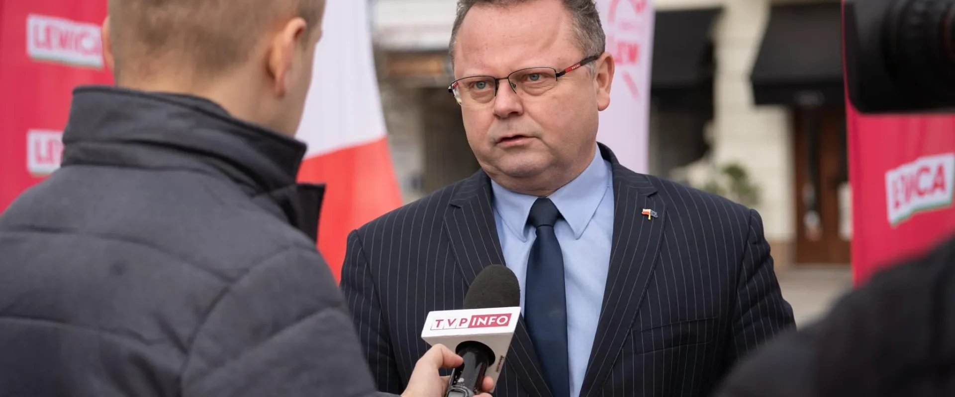 Mężczyzna w garniturze i okularach udziela wywiadu nt. strategii NATO w odstraszaniu Rosji przed kamerami TVP Info.