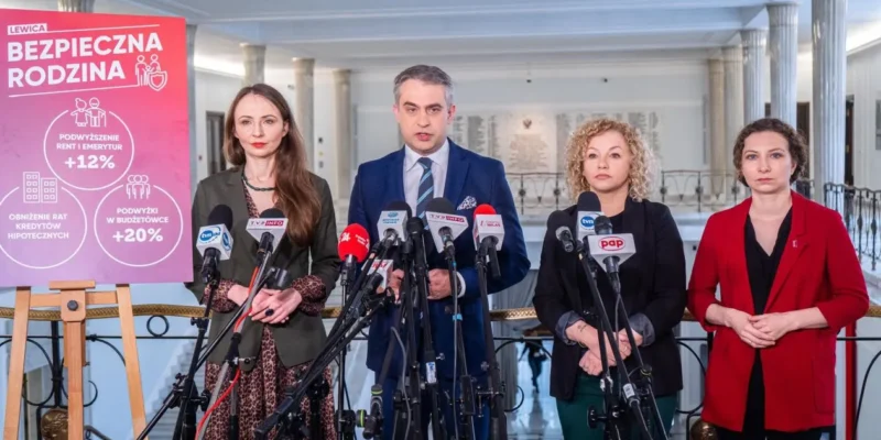 Na zdjęciu widoczna jest konferencja prasowa z czterema osobami stojącymi przed mikrofonami oraz planszą prezentującą propozycje polityczne związane z bezpieczeństwem rodziny.