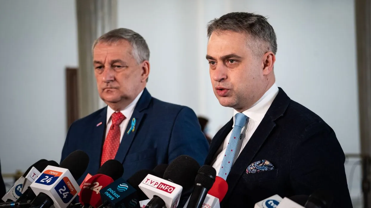 Dwaj mężczyźni podczas konferencji prasowej, stojący przy mikrofonach i wyrażający swoje stanowiska.