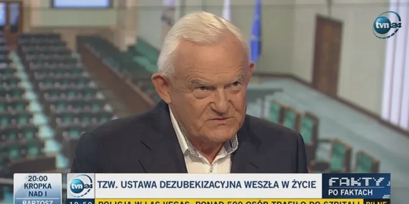 Starszy mężczyzna w garniturze udzielający wywiadu w studiu telewizyjnym, z widocznym paskiem informacyjnym o wejściu w życie ustawy dezubekizacyjnej.