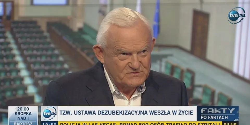 Starszy mężczyzna w garniturze udzielający wywiadu w studiu telewizyjnym, z widocznym paskiem informacyjnym o wejściu w życie ustawy dezubekizacyjnej.