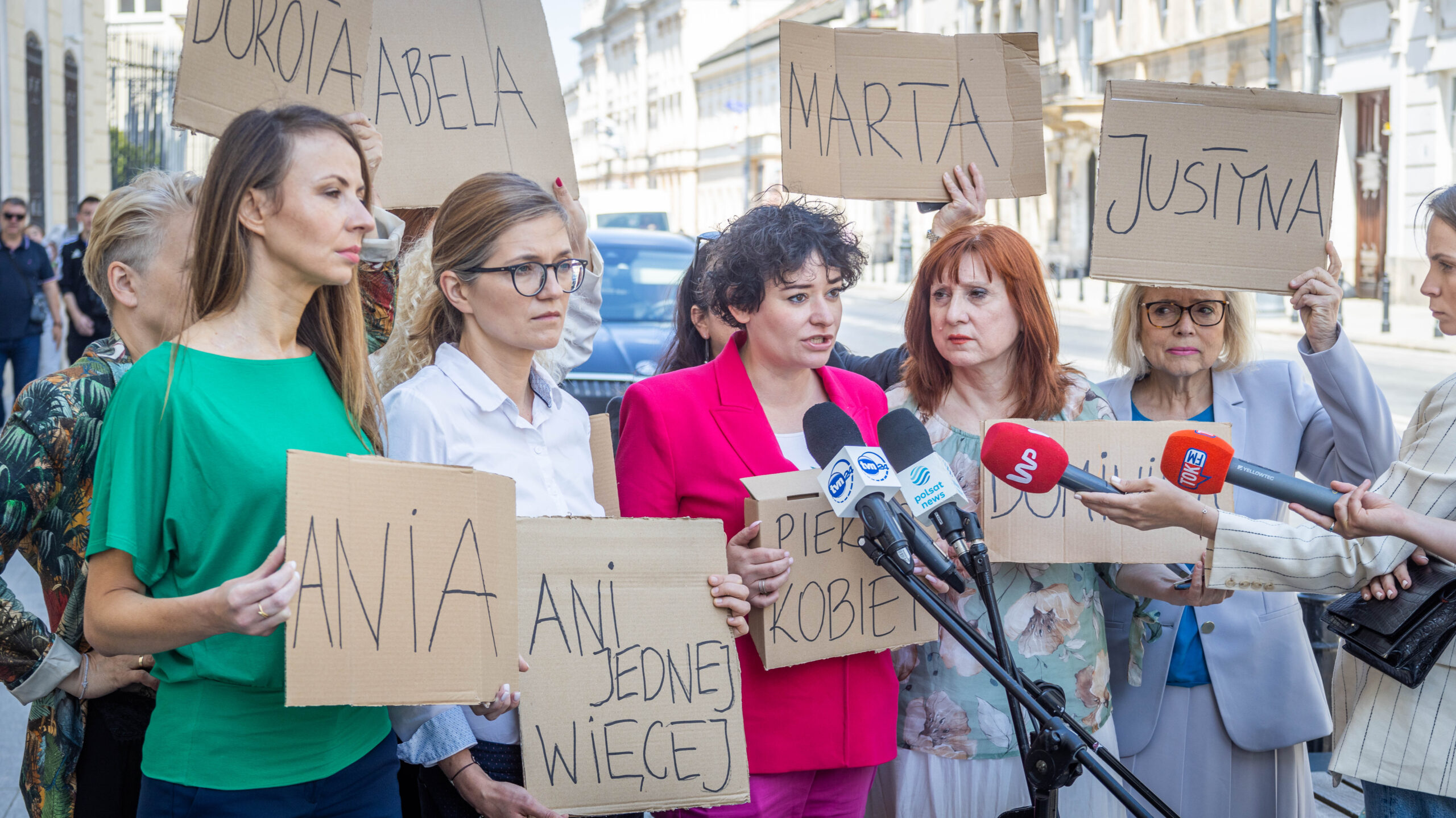 Kilka kobiet na ulicy trzyma kartonowe plakaty z imionami i udziela wywiadu mediom podczas protestu przeciwko surowemu prawu antyaborcyjnemu w Polsce.