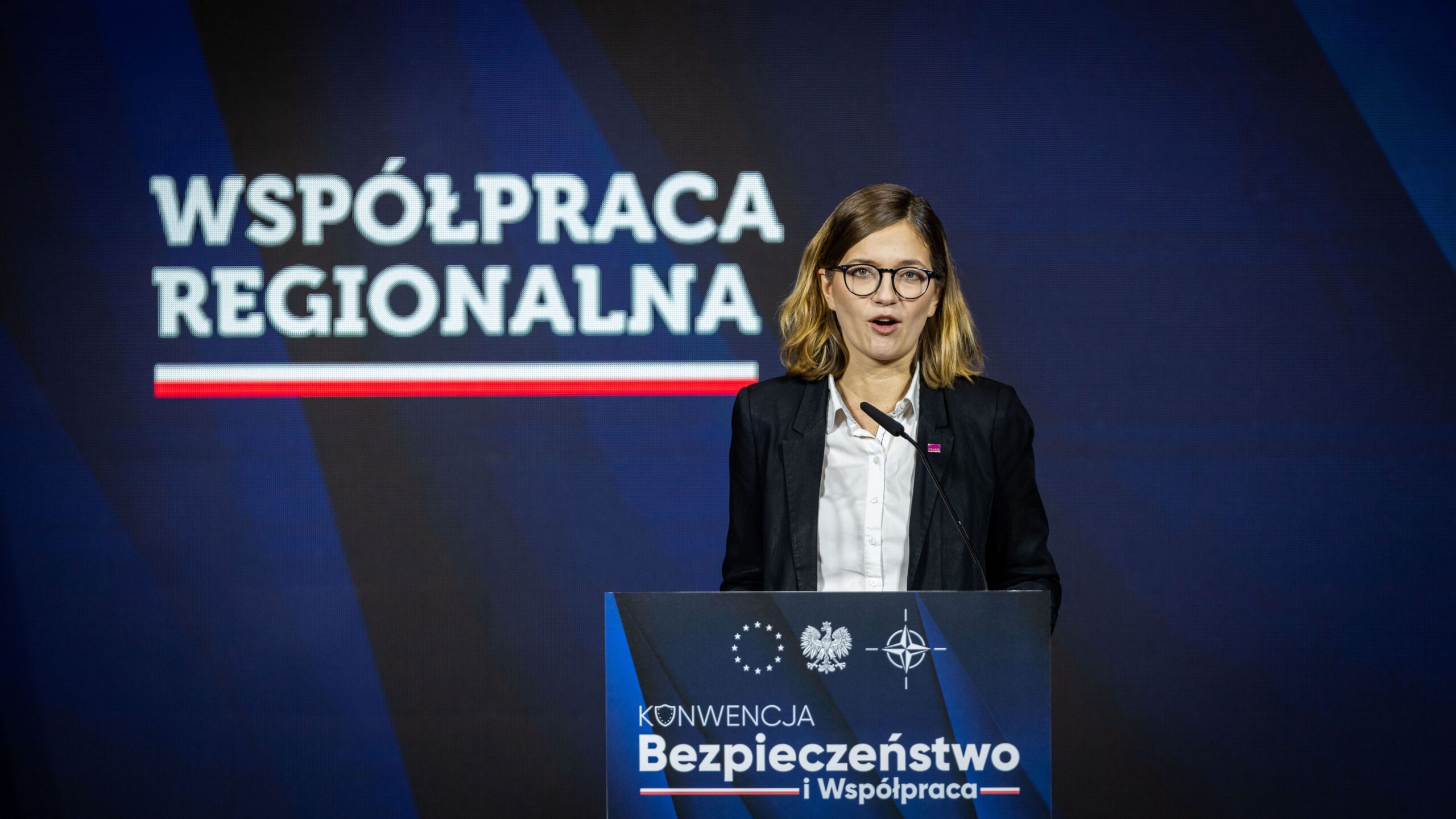 Na zdjęciu widać kobietę przemawiającą z mównicy podczas konferencji na temat współpracy regionalnej w kontekście bezpieczeństwa.