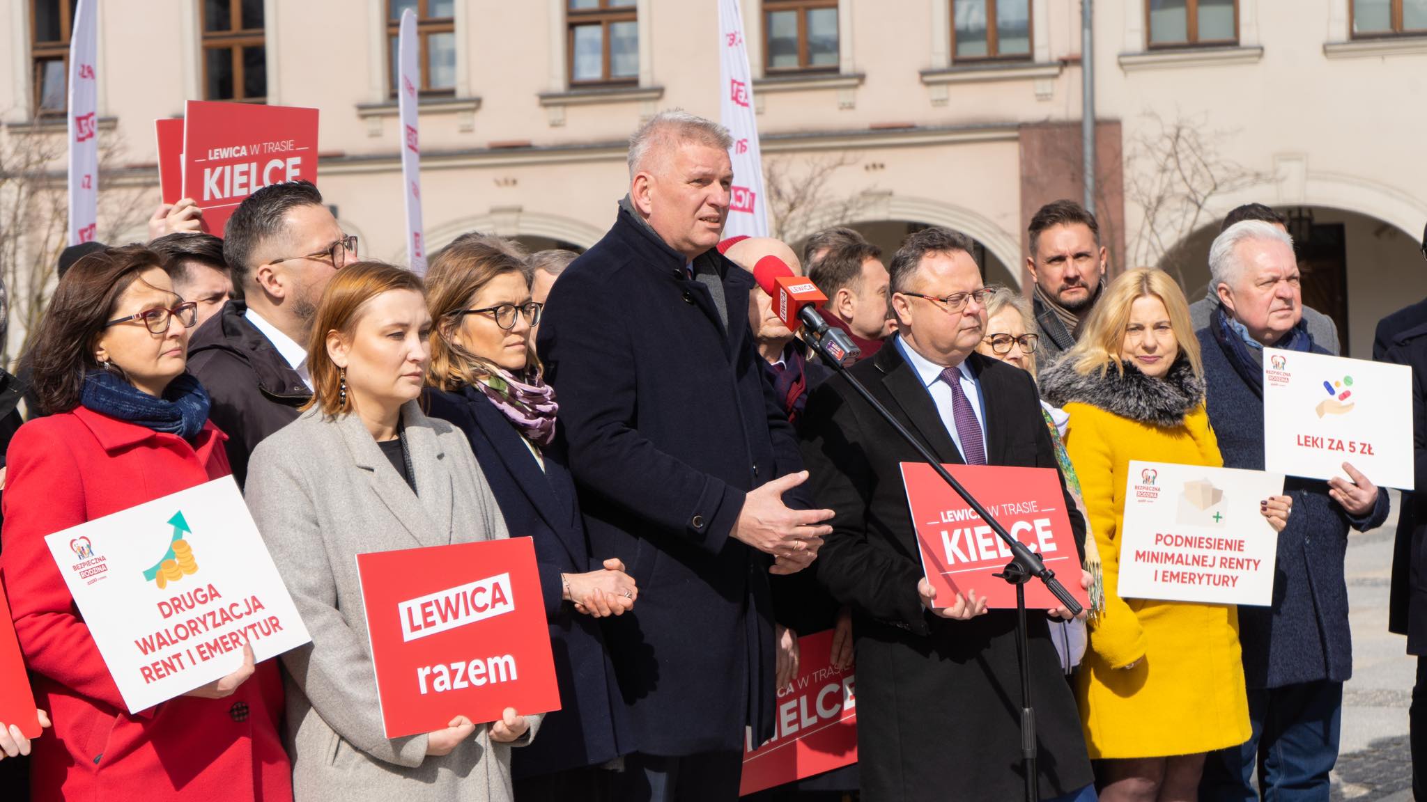 Na zdjęciu przedstawiono grupę osób podczas konferencji prasowej z hasłami dotyczącymi renty i emerytur w Kielcach.