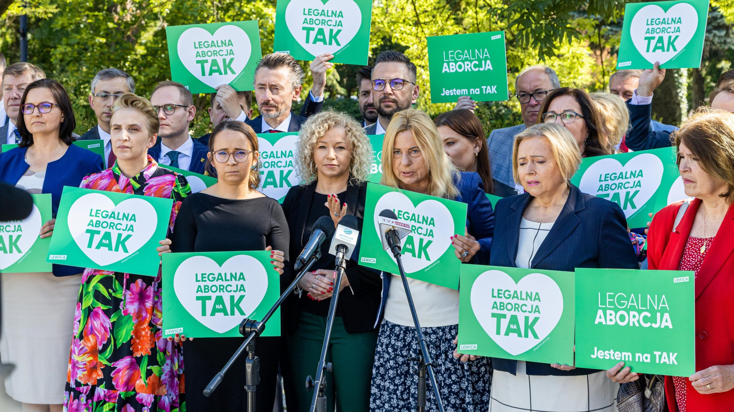 Na zdjęciu grupa ludzi trzyma transparenty z hasłami na rzecz legalizacji aborcji podczas wiecu protestacyjnego.