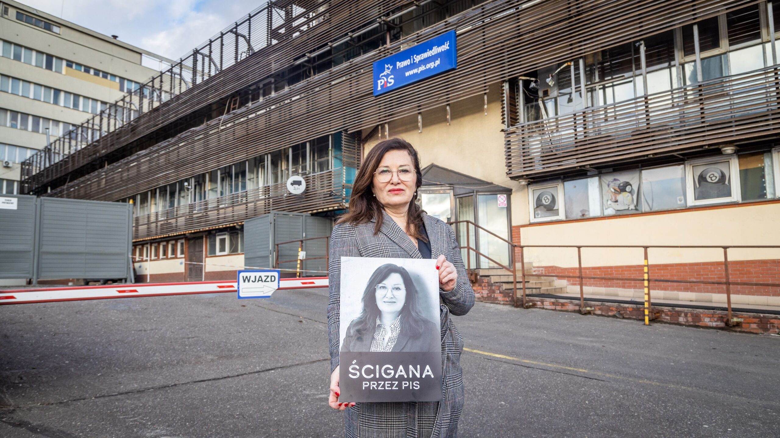 Na zdjęciu widoczna jest kobieta trzymająca plakat z napisem 