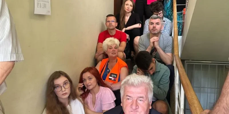 Grupa osób, w tym posłowie Lewicy, zajmuje klatkę schodową podczas blokady nielegalnej eksmisji w Warszawie.