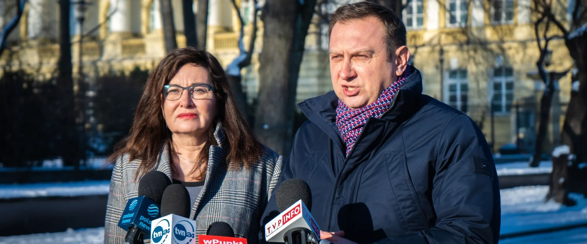 Na zdjęciu widać dwóch mówców podczas konferencji prasowej na tle zimowego krajobrazu.