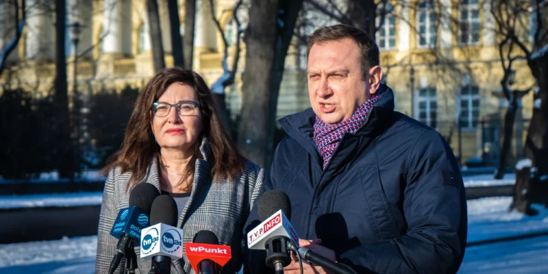 Na zdjęciu widać dwóch mówców podczas konferencji prasowej na tle zimowego krajobrazu.