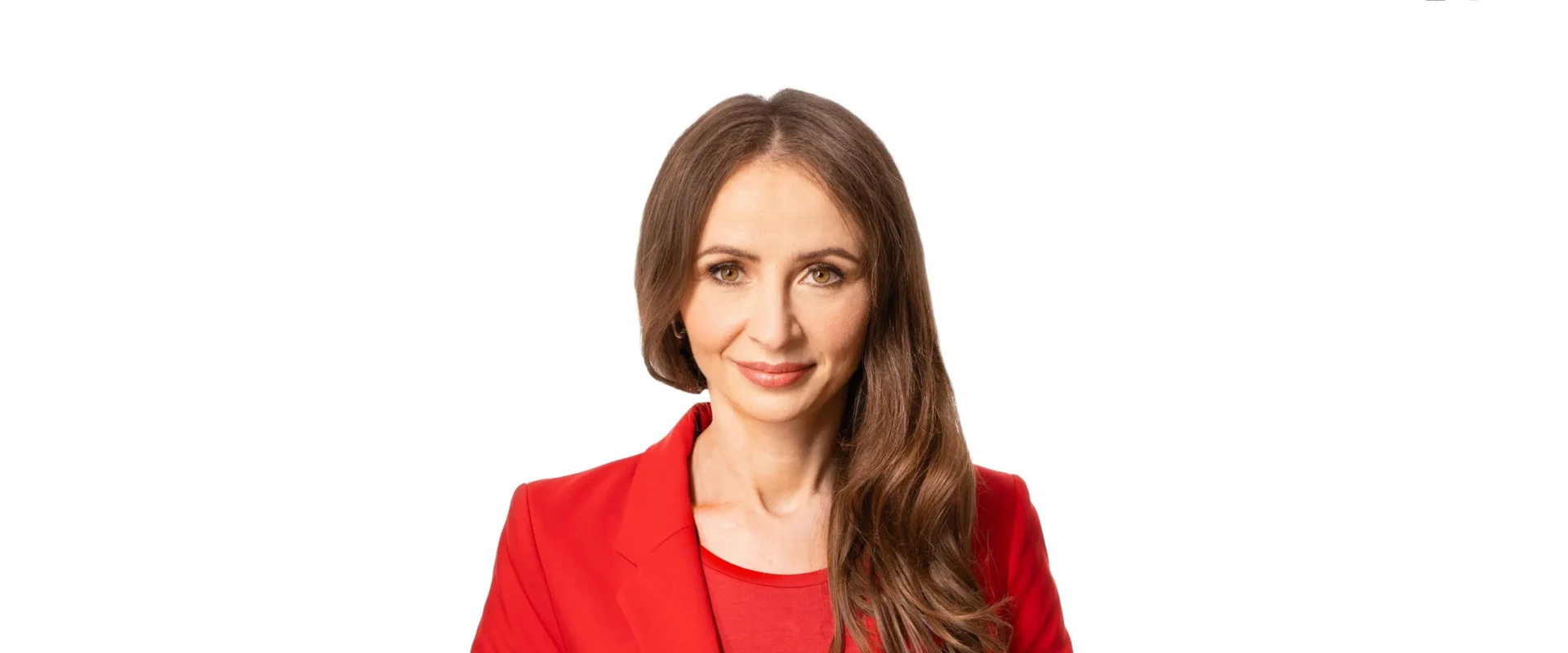 Portret kobiety z długimi brązowymi włosami, ubranej w czerwony żakiet, na białym tle.