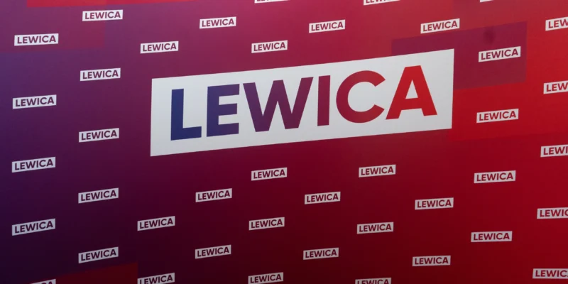 Tło w odcieniach purpury i czerwieni z licznymi napisami LEWICA oraz dużym napisem LEWICA w białej ramce, upamiętniające uchwałę Rady Krajowej Nowej Lewicy z okazji 25. rocznicy Konstytucji RP.