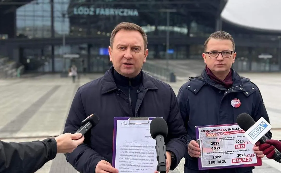 Na zdjęciu prezentują się dwaj mężczyźni podczas konferencji prasowej przed dworcem Łódź Fabryczna, trzymając materiały dotyczące aktualizacji cen biletów.