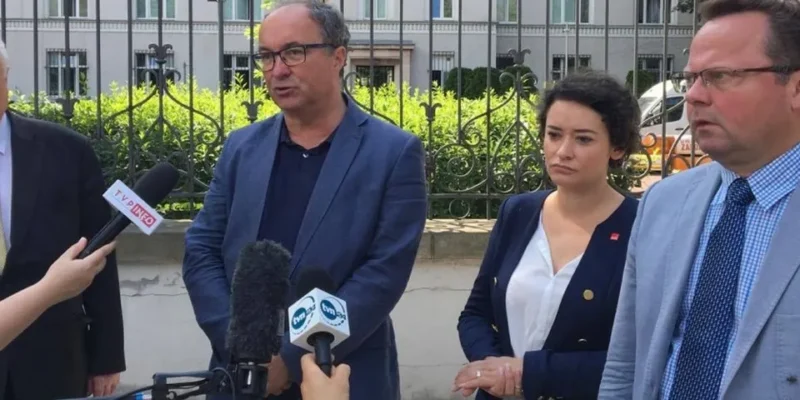 Grupa polityków udzielająca oświadczenia przed budynkiem, stojąca przy mikrofonach i apelująca do prezydenta o trzecie weto.