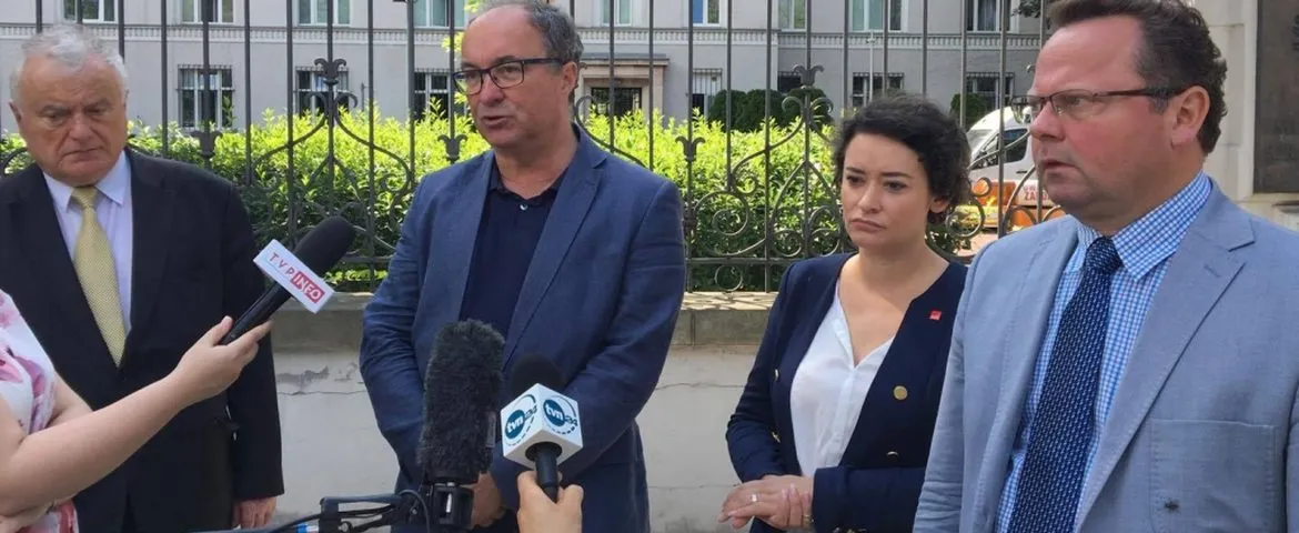 Grupa polityków udzielająca oświadczenia przed budynkiem, stojąca przy mikrofonach i apelująca do prezydenta o trzecie weto.