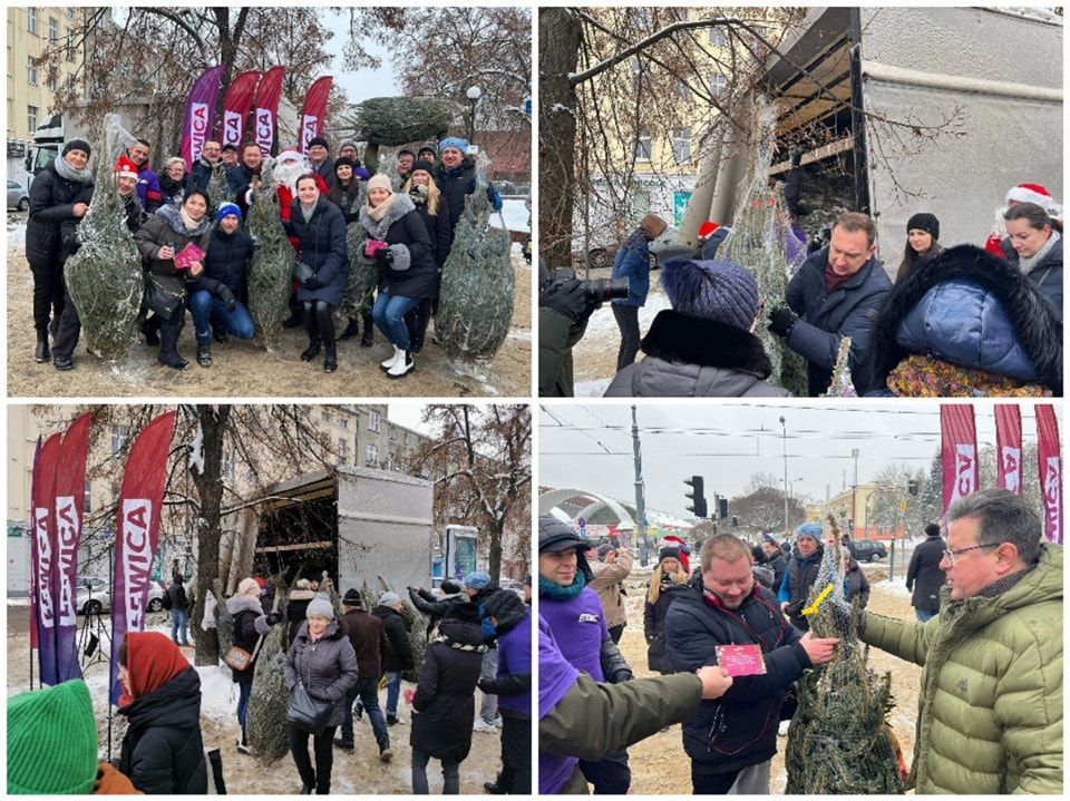 Na zdjęciu widoczna jest grupa ludzi w zimowych ubraniach, pozująca z choinkami w tle, podczas świątecznej akcji w Łodzi.