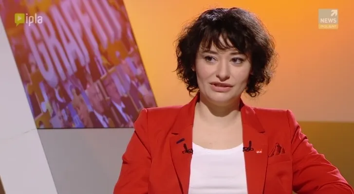 Kobieta w czerwonej marynarce siedzi w studiu telewizyjnym podczas wywiadu o rodzinach i związkach nieformalnych.