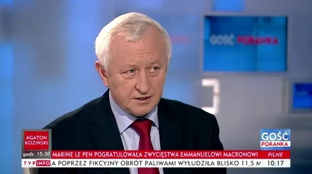 Mężczyzna w marynarce i czerwonym krawacie wypowiada się w studiu telewizyjnym podczas programu informacyjnego "Gość Poranka".