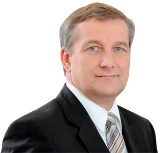 Portret mężczyzny w czarnym garniturze, białej koszuli i paskowanym krawacie na białym tle.