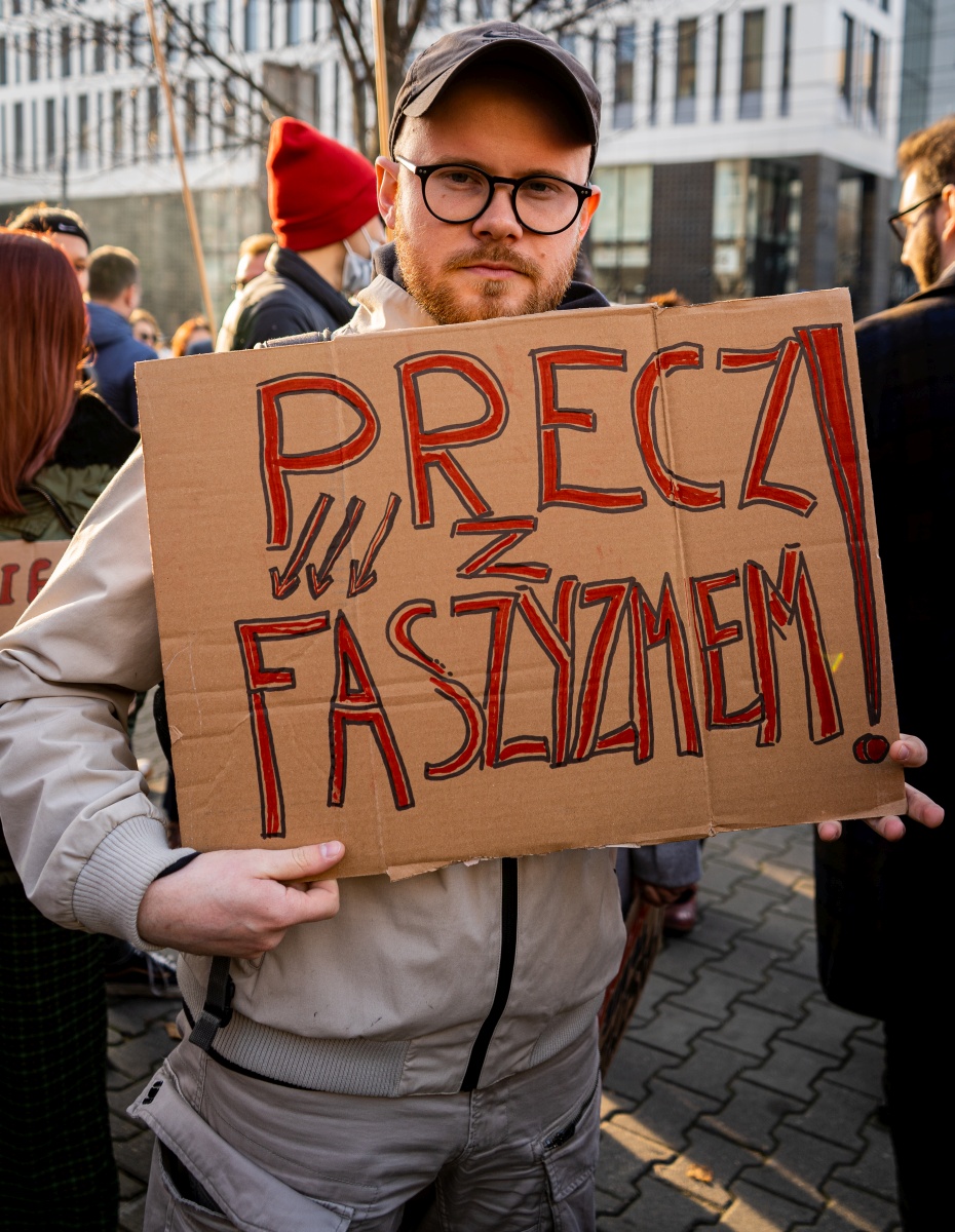 Mężczyzna trzyma kartonowy znak z napisem 