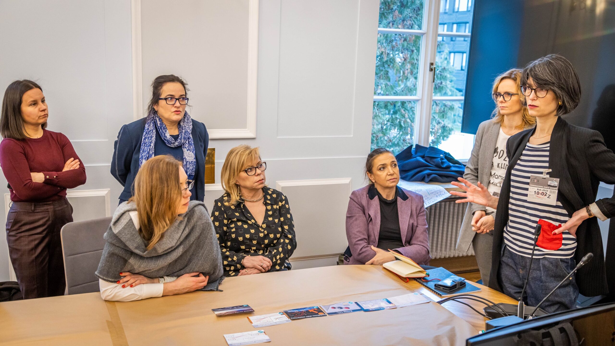 Grupa kobiet w sali konferencyjnej Sejmu rozmawia o projekcie Mozaika Klimatyczna; stojąca kobieta przemawia do pozostałych.